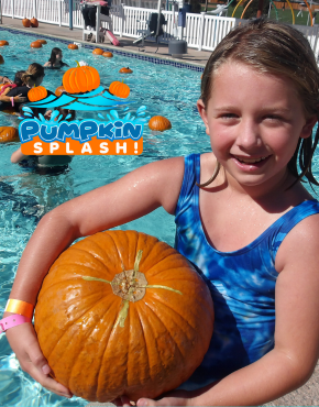 Girl in swimsuit holding large pumpkin next to floating pumpkin patch