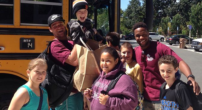 Teens getting off yellow school bus